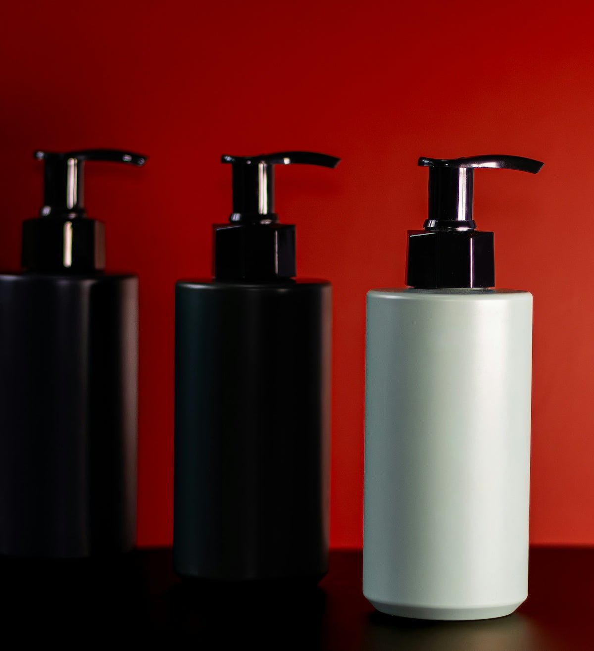 Three pump bottles on a red background