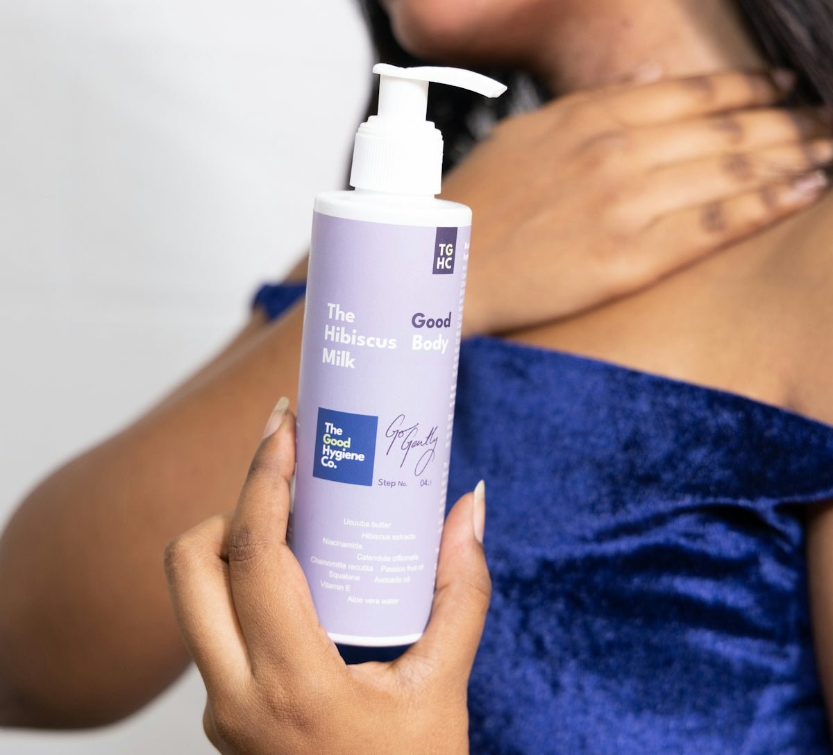 Woman holding a bottle of hibiscus milk lotion