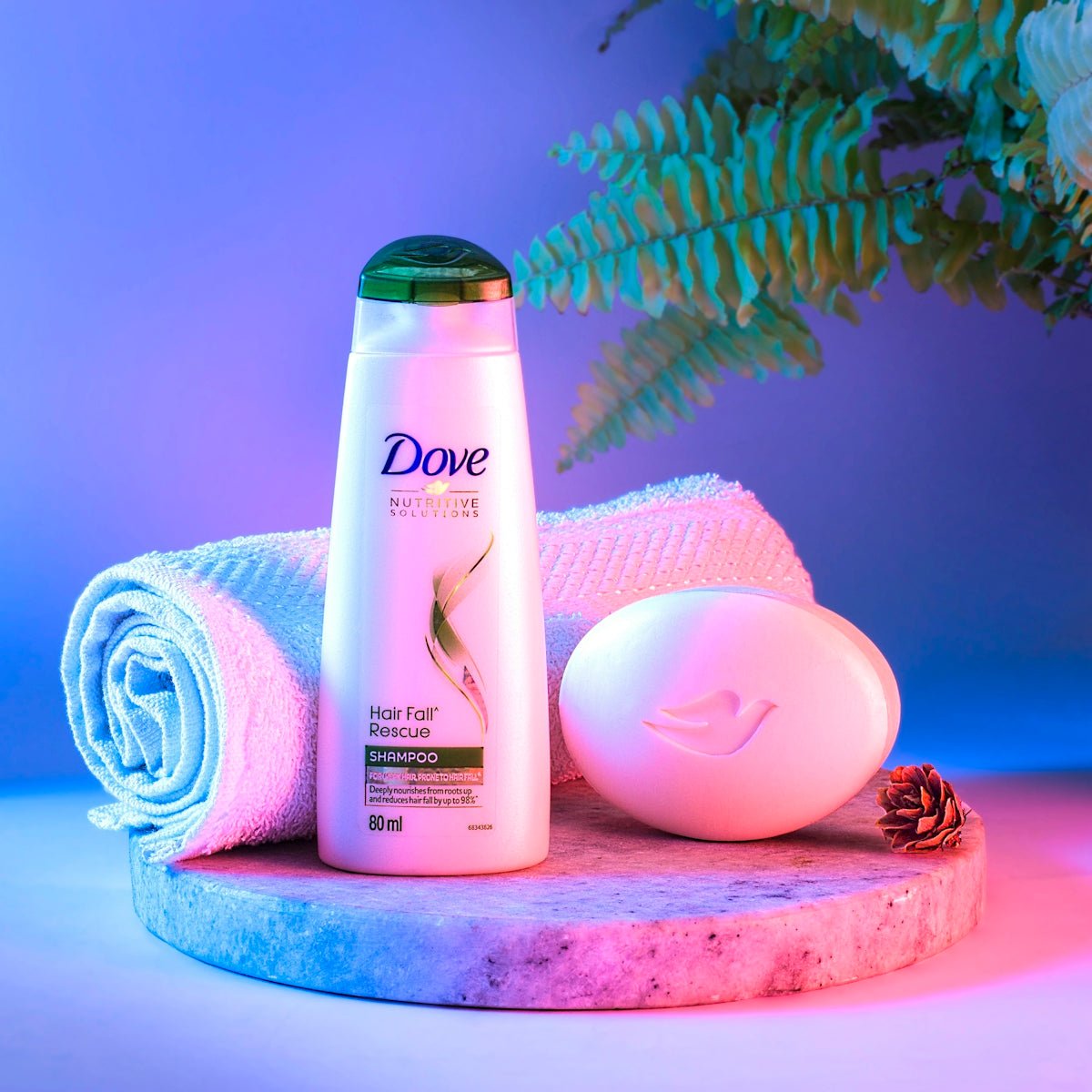 a bottle of dove body lotion next to a pile of towels