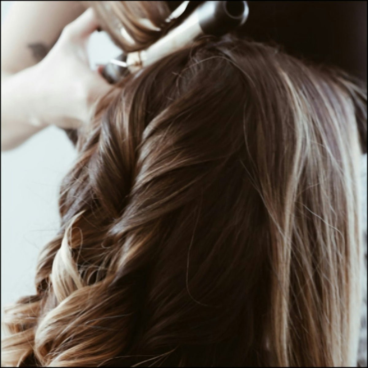 A woman getting her hair done by a hair stylist