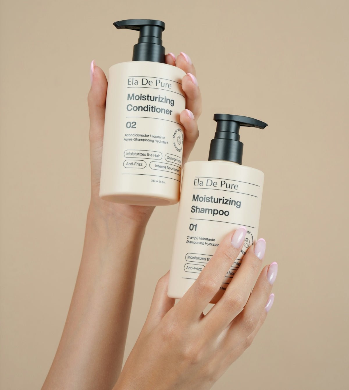 Two hands hold bottles of shampoo and conditioner.